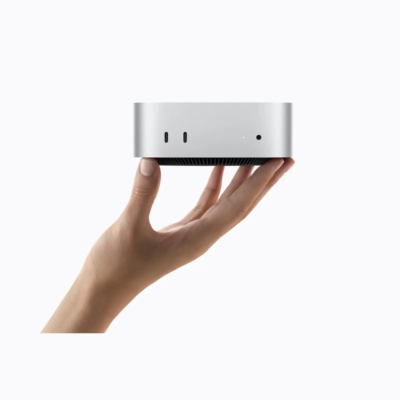Apple Mac mini with M6 chip held in one hand
