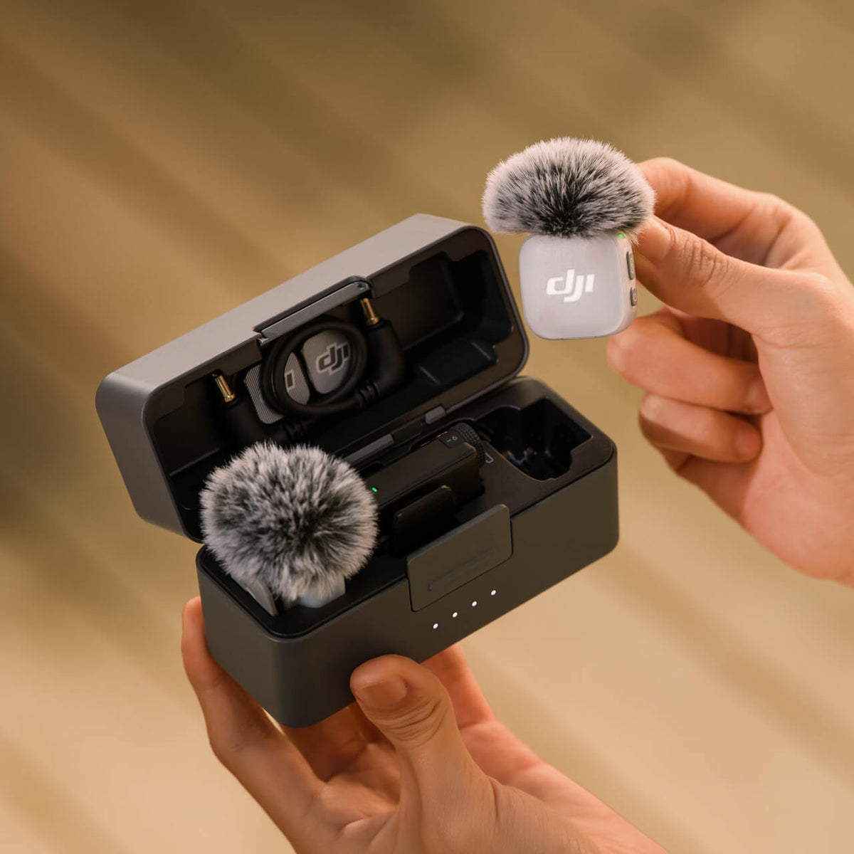 مرسل DJI Mic Mini 2 بإسفنجة هواء فوق علبة الشحن المفتوحة