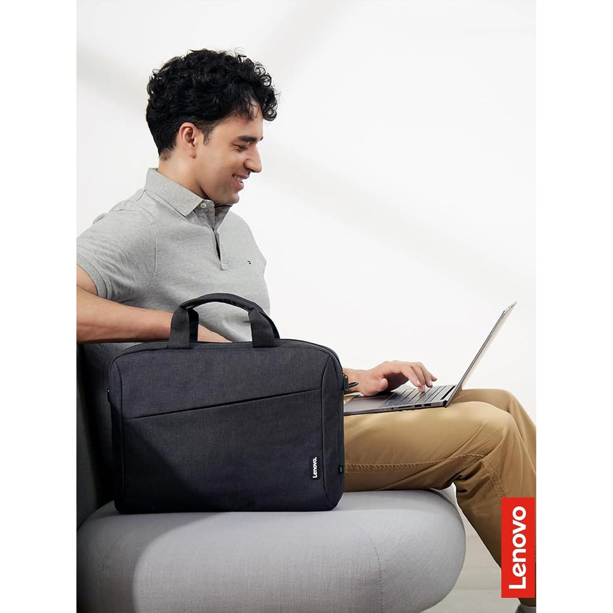 Lenovo T210 15.6-inch Laptop Casual Toploader in Black, on a lap next to a laptop
