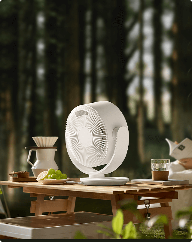 مروحة Xiaomi Smart Desktop Air Circulation Fan على طاولة خشبية وسط غابة
